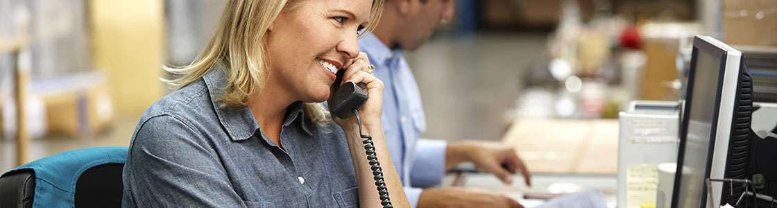 A businesswoman using a factory telephone system